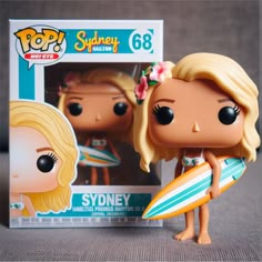 a pop vinyl figurine holding a surfboard in front of a cardboard box