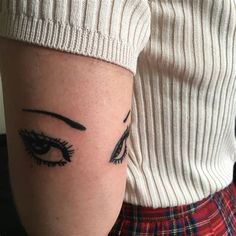 a woman's arm with an eye tattoo on the left side of her body