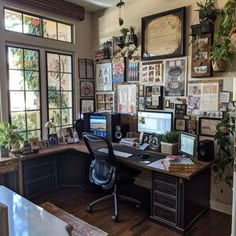 a home office with lots of plants and pictures on the wall