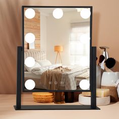 a mirror that has some lights on it in front of a bed and other items