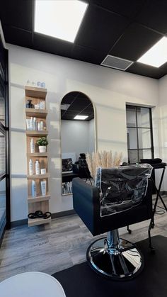 an empty salon room with black chairs and white walls