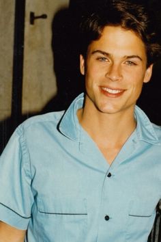 a smiling young man wearing a blue shirt