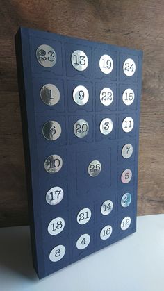 a blue card with numbers on it sitting next to a wooden wall and a clock