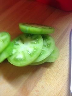 some green peppers on a cutting board next to a knife