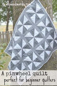 a black and white quilt hanging on a tree