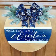 a wooden sign that says walking in a winter wonderland with blue and white snowflakes on it