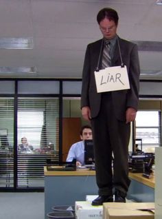 a man standing on top of boxes in an office cubicle holding a sign that says lar