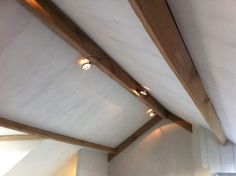 an empty room with white walls and wood beams