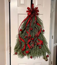 a door decorated with a christmas tree and red ribbon