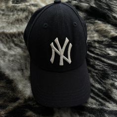 a new york yankees hat laying on top of a fur rug