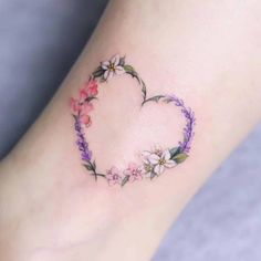 a heart shaped tattoo with flowers around it