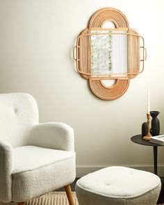 a chair and ottoman in a room with a mirror on the wall above it, next to a small table