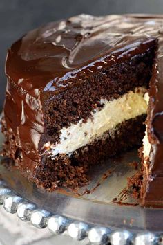 a close up of a cake with chocolate frosting and one slice missing from it