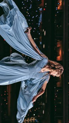 a woman in a blue dress is reflected in the water