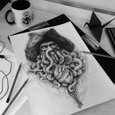 an octopus drawing on paper next to a coffee cup