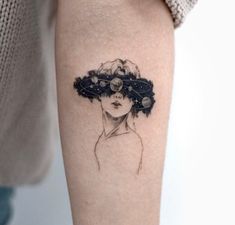 a woman's arm with a black and white tattoo design on the left forearm