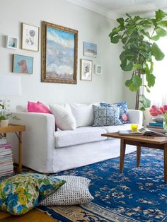 a living room filled with lots of furniture and flowers in vases on the table