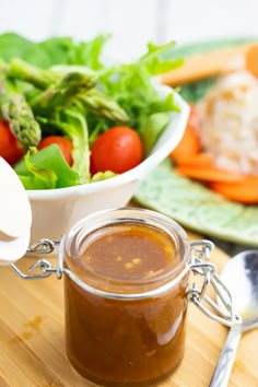 a salad with dressing in a jar on a cutting board