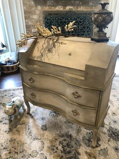 an antique dresser with gold leafy decorations on top