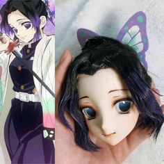 an anime doll with blue eyes and black hair is shown next to a hand holding a doll