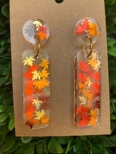 the earrings are decorated with orange and yellow leaves