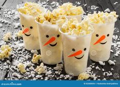 four cups with popcorn in the shape of snowmen