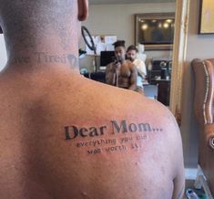 a man with a tattoo on his back saying dear mom