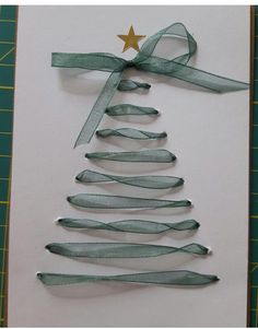 a christmas tree made out of ribbon on top of a piece of paper with a gold star