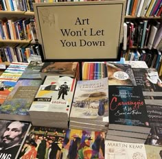 there are many books on display in the library and one sign says art won't let you down