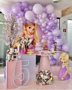 there is a birthday cake and balloons in the room with princesses on it's table