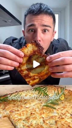 a man eating a piece of pizza on top of a wooden table