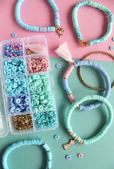 beads, bracelets and necklaces laid out on a pink table with other items