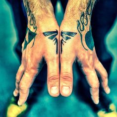 two hands that have tattoos on them