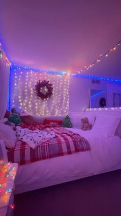 a bedroom decorated for christmas with lights on the ceiling and bed in front of it