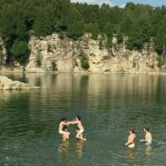 some people are playing in the water near rocks