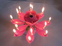 a pink flower with lit candles in it