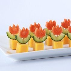 cucumber and cheese appetizers with watermelon on them are displayed on a white plate