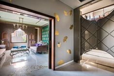 a living room filled with lots of furniture and walls covered in gold leaf decals