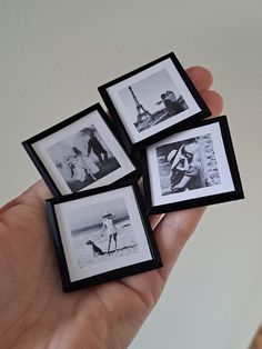 four small black and white pictures are held in a hand