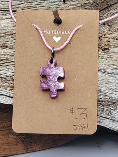 a necklace with a purple puzzle piece on it