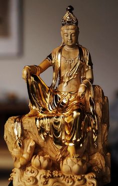 a golden buddha statue sitting on top of a table