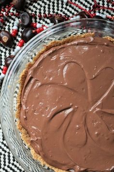 a chocolate pie sitting on top of a glass plate