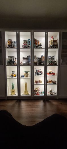 a dog laying on the floor in front of an open display case with model cars