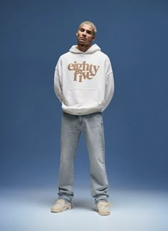 a man standing in front of a blue background wearing a white hoodie with the words catchhy five printed on it