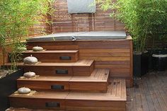 a wooden deck with steps and plants on it