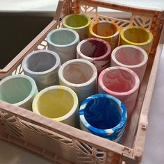 there are many different colored cups in the basket