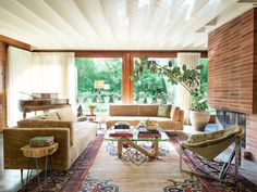 a living room filled with furniture and a fire place in front of a large window