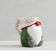 a ceramic figurine sitting on top of a white table next to a gray wall