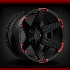 a black and red wheel with red trims on the rim, against a dark background