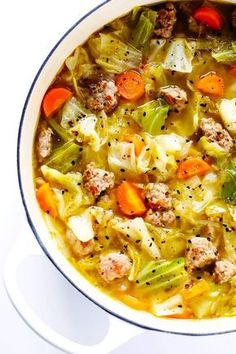 a white bowl filled with meat and vegetable soup